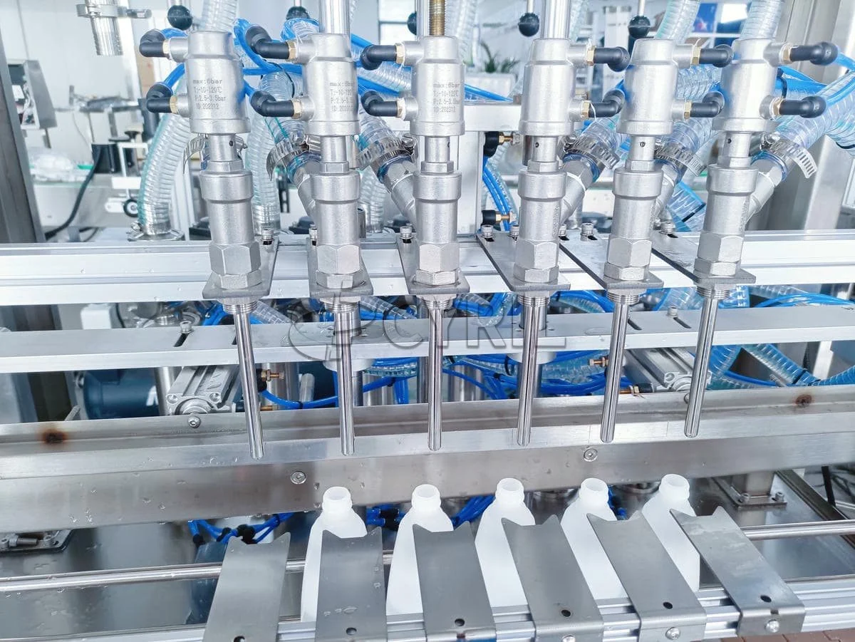 Close-up of filling heads and bottle guides on a packaging machine